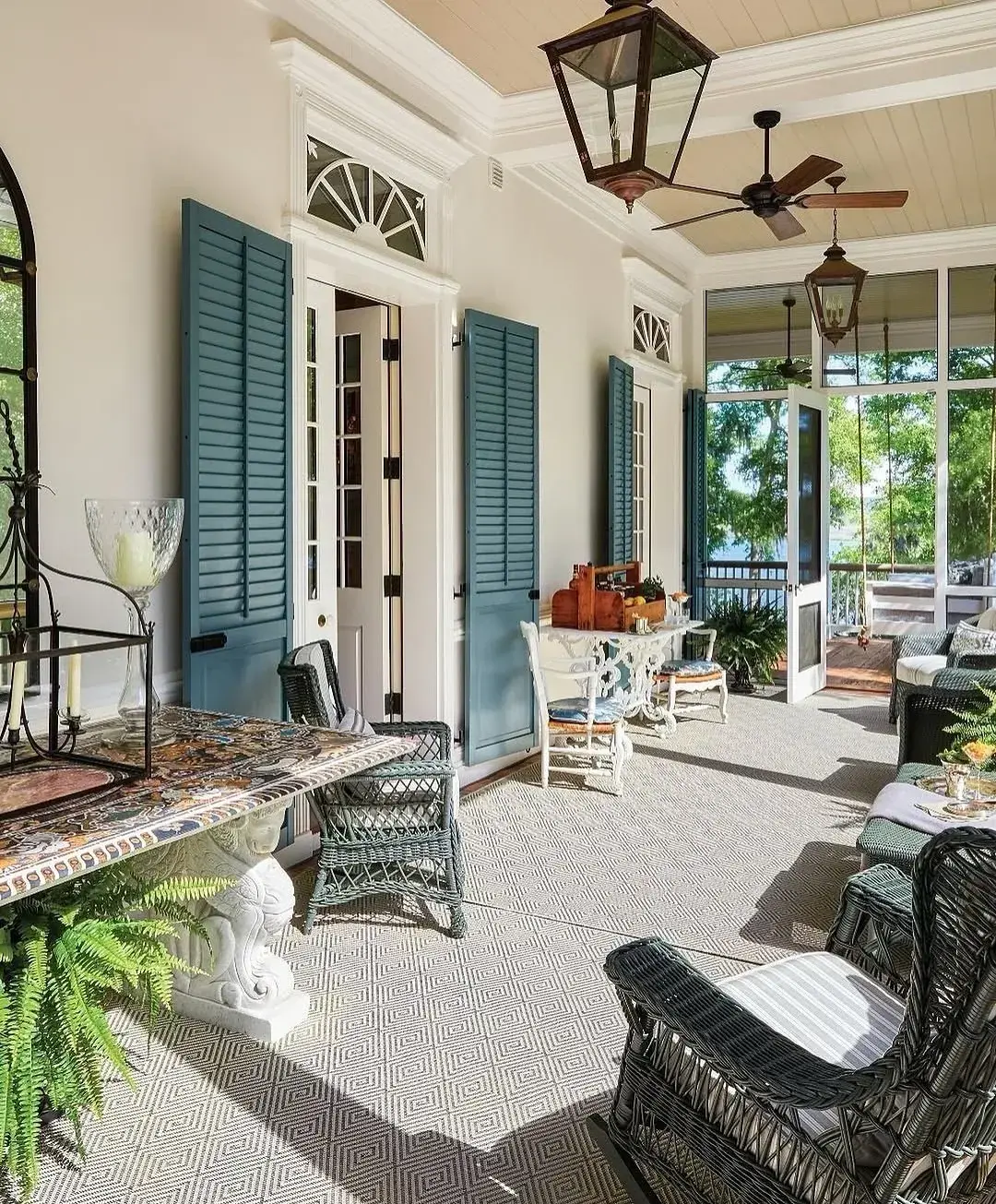 Covered porch with teal louvred shutters framing white French doors