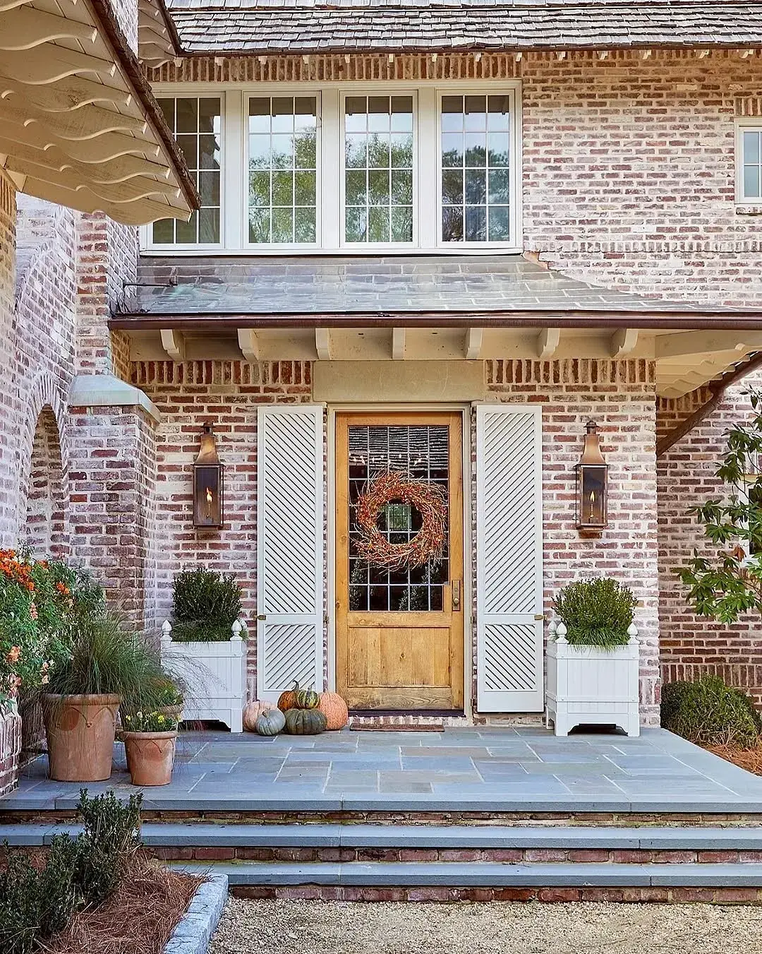 Brick porch with slate floor, slate treads and timber door with wreath