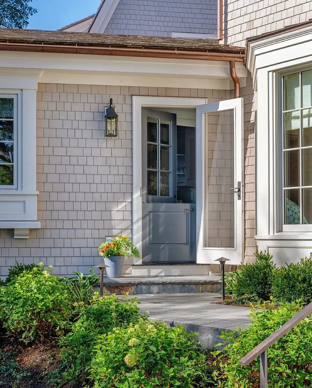 Shingle house with grey Dutch door, stone threshold and cottage planting