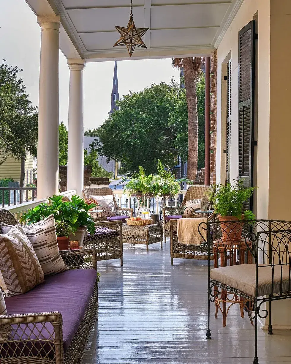 Covered porch with columns, wicker furniture and a star pendant seen down its length