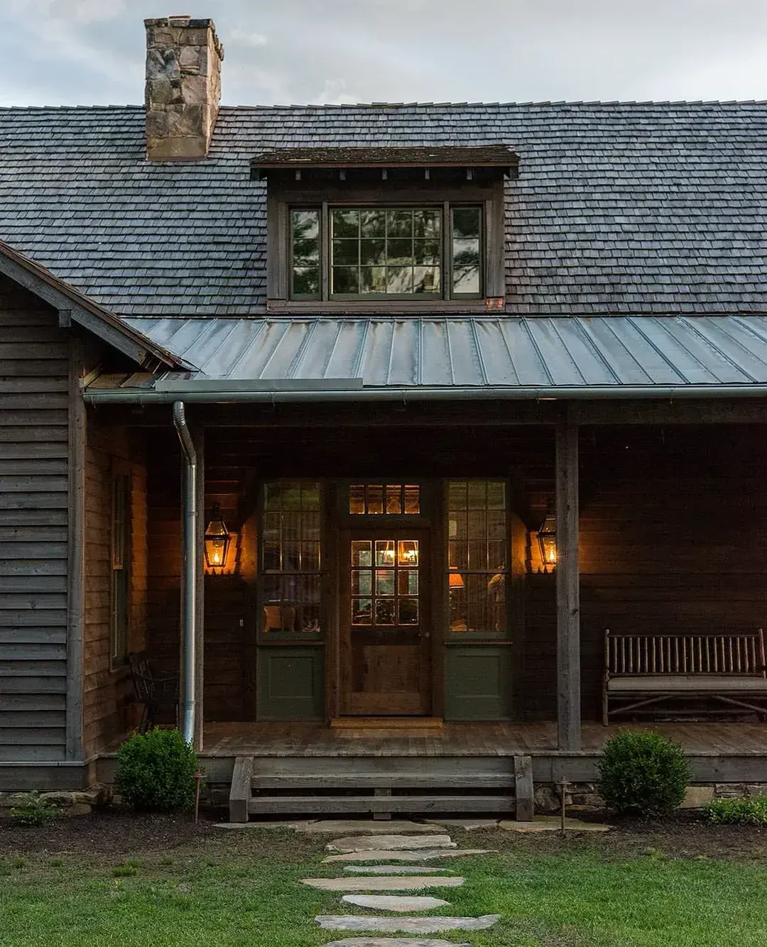 Dark timber lodge with a standing seam metal porch roof