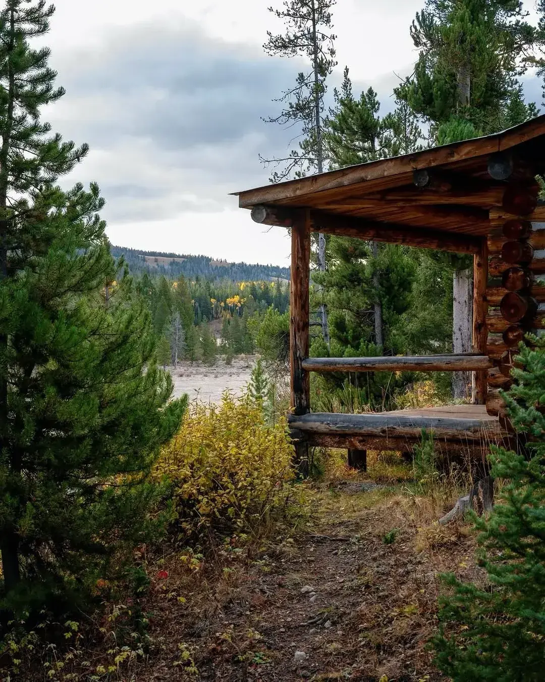 Rustic log cabin with a deep covered porch in the mountains