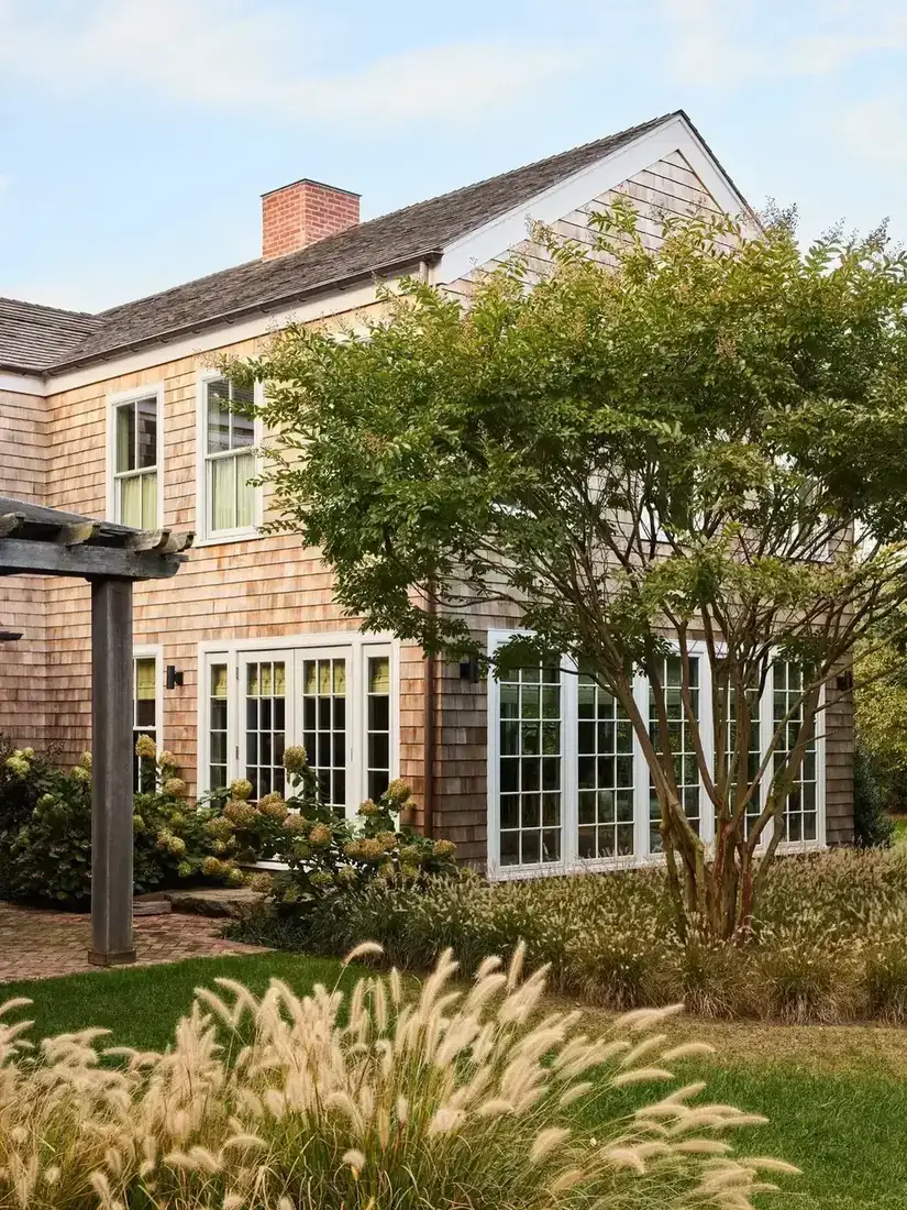 Cedar shingle house with crisp white window trim and rake boards against weathering shingle