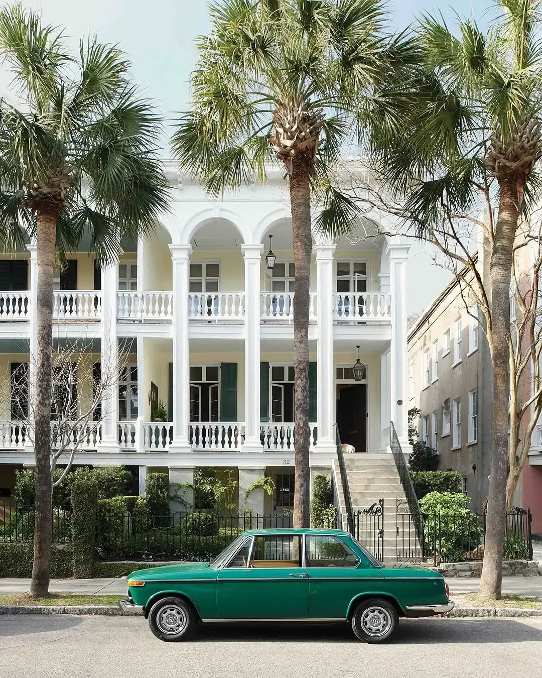 White Charleston double porch with palm trees