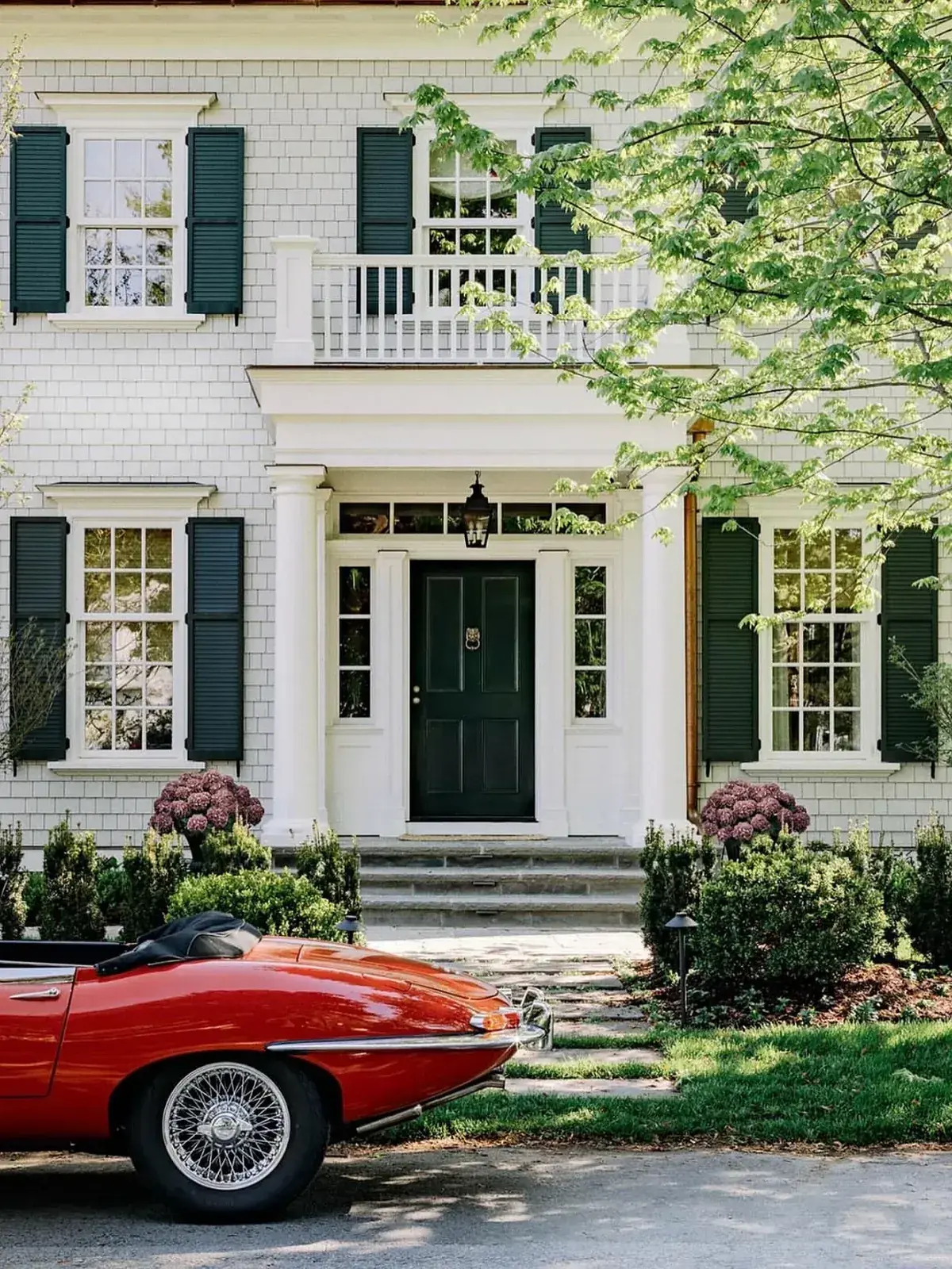 White clapboard Greek Revival house with green shutters
