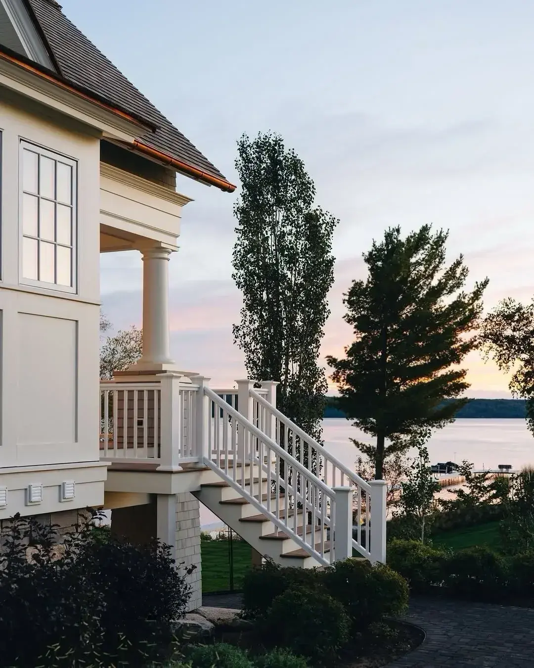 White lake house porch with a stair railing leading down