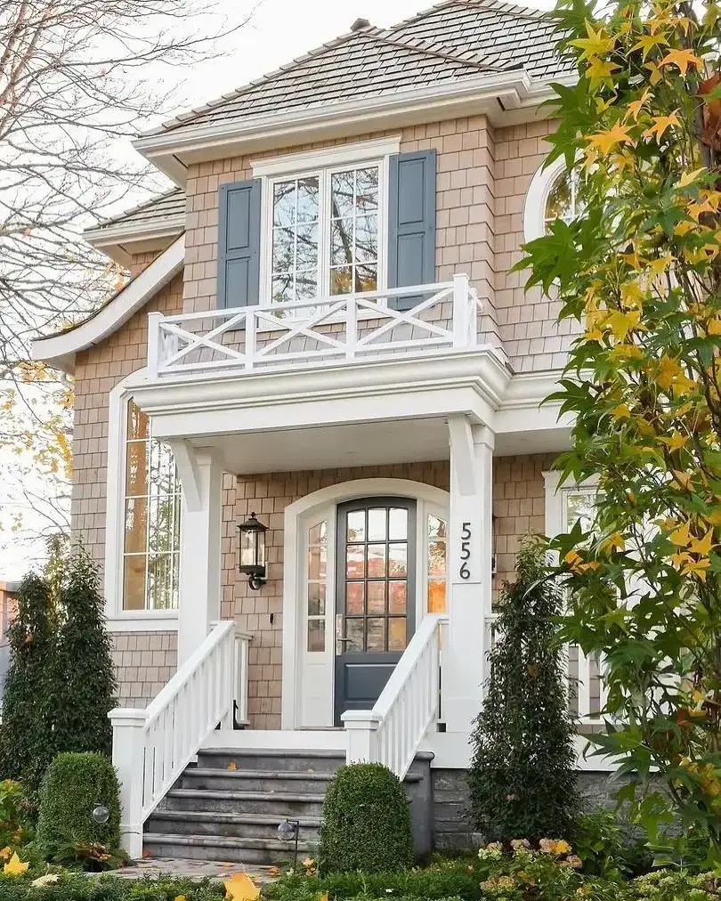 Large shingle style home with symmetrical gables set behind a lawn