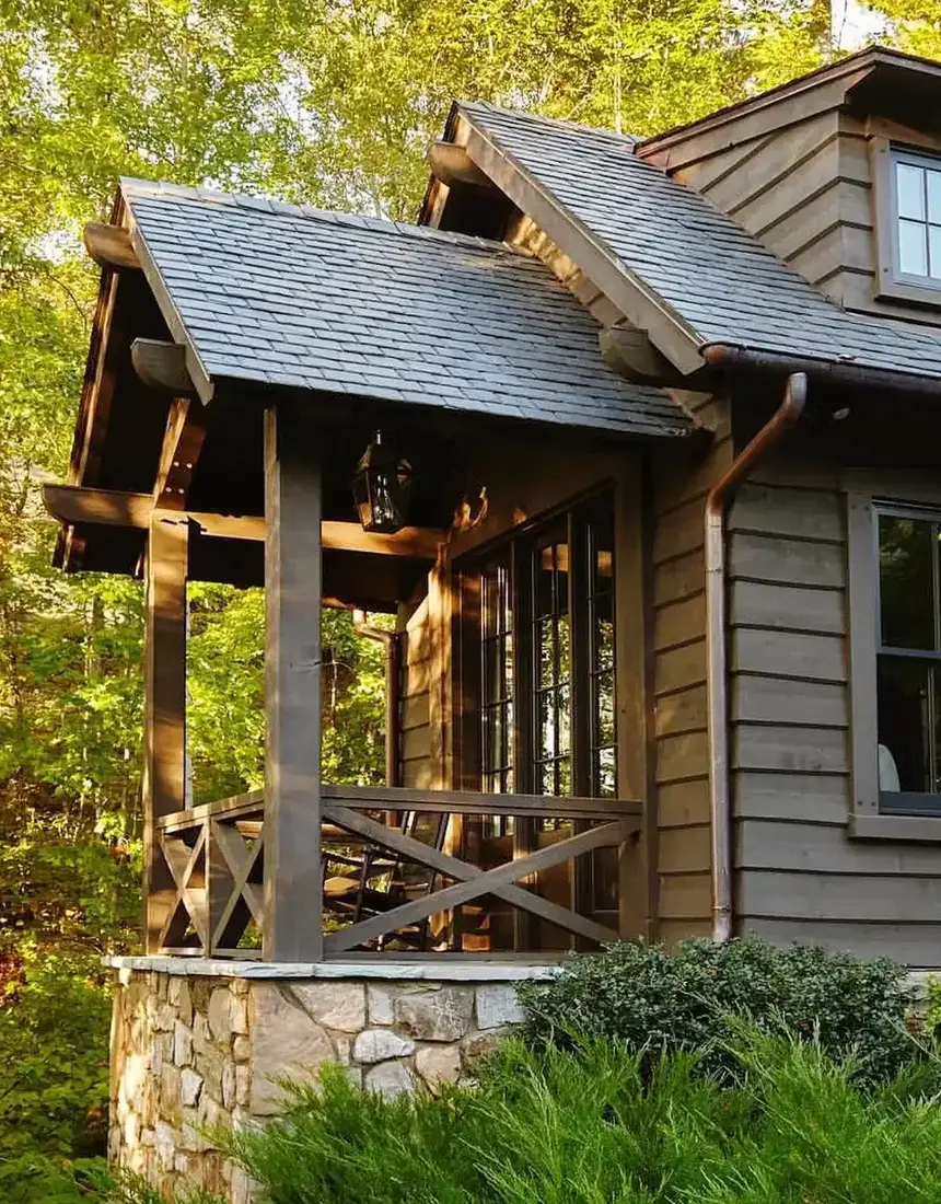 Dark timber porch with chunky posts standing on a tall stone pedestal capped with a projecting slab
