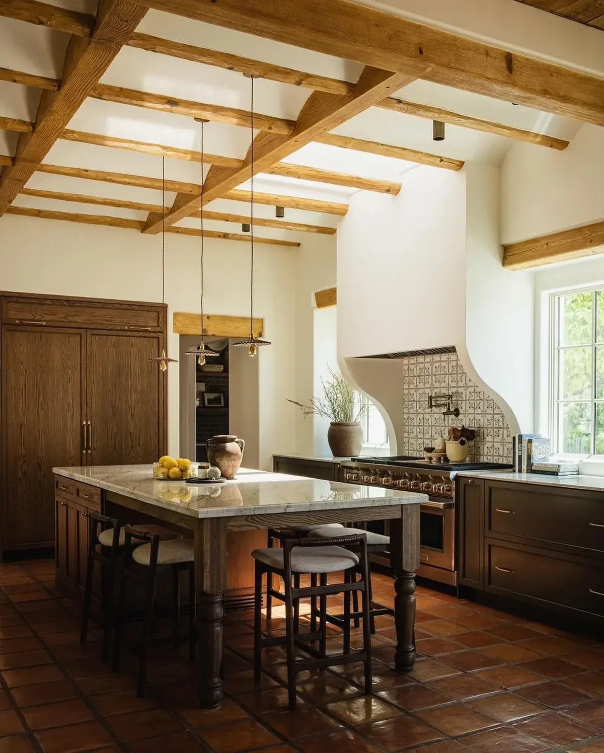 Pine rafters meeting a high white ridge above a dark oak island with a marble top