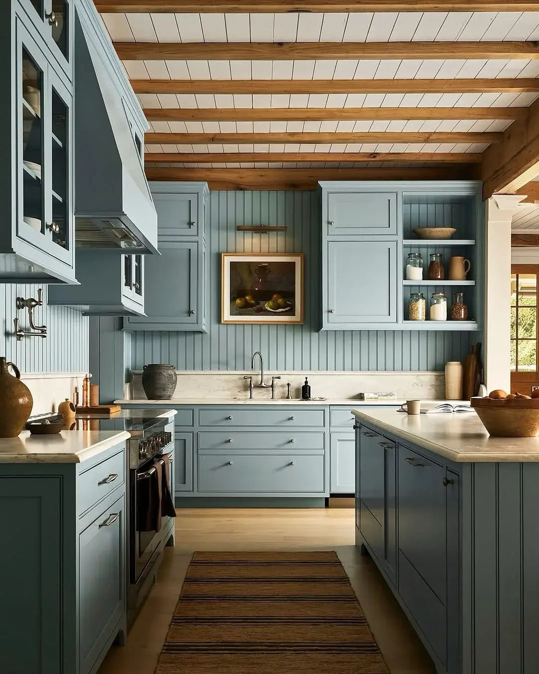 Blue-grey kitchen with matching beadboard backsplash under a warm oak plank ceiling