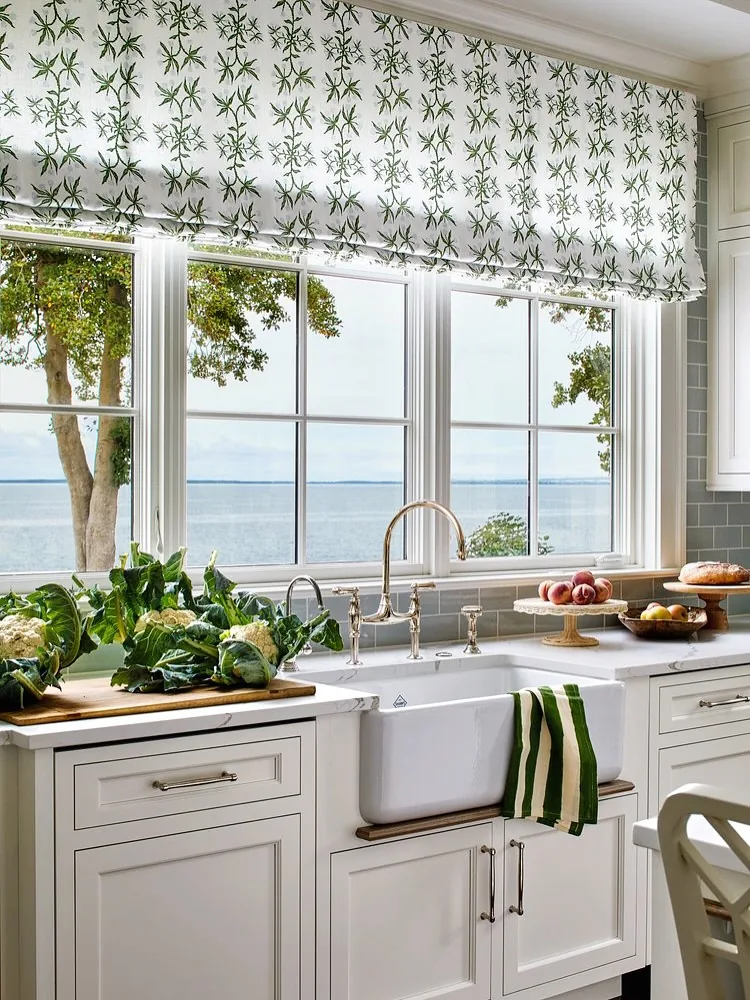 Botanical Roman blind mounted high above a run of kitchen windows over a sink