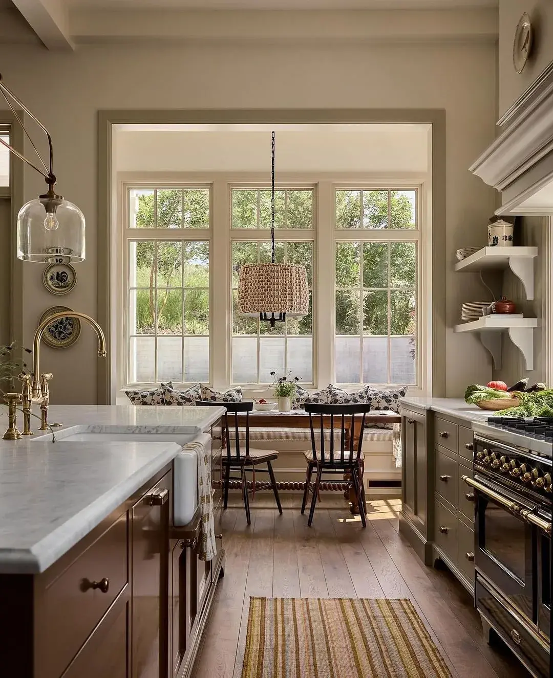Bay window breakfast nook with built in banquette, timber table, black chairs and woven pendant