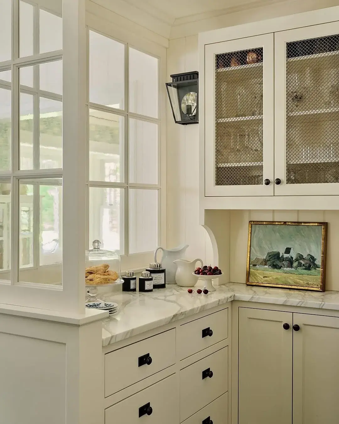 White corner pantry with wire mesh glazed uppers, interior window and marble top