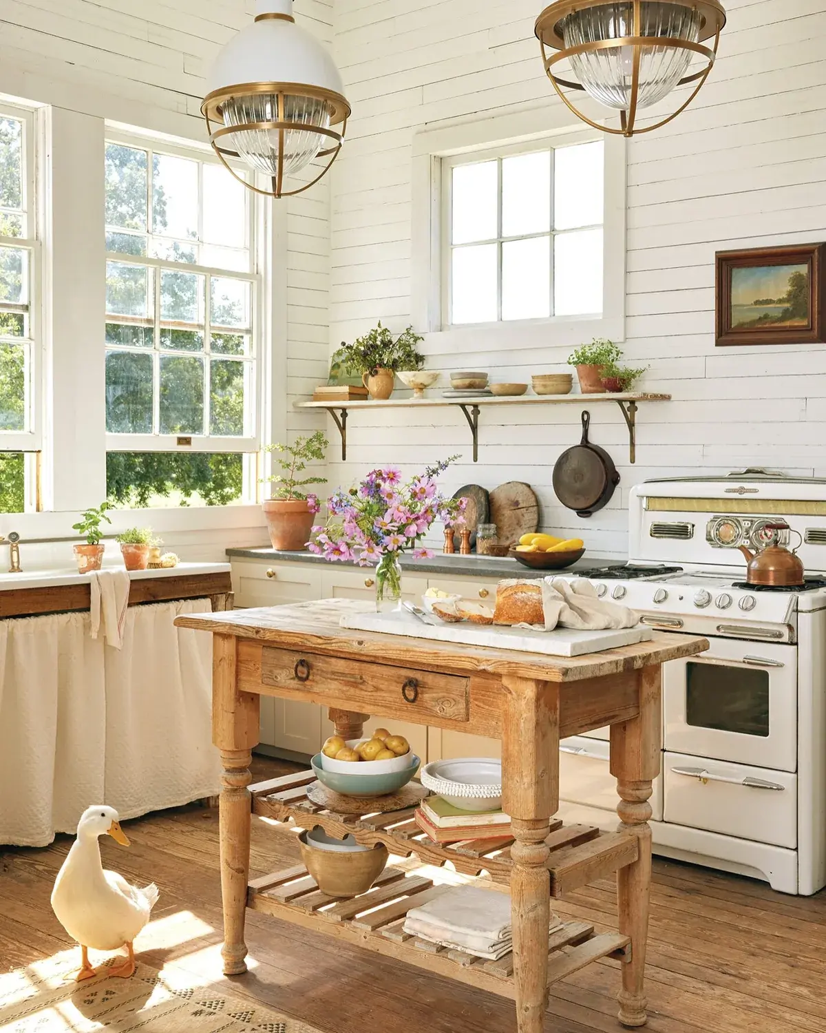 White boarded kitchen with pine prep table, vintage cooker and sink curtain