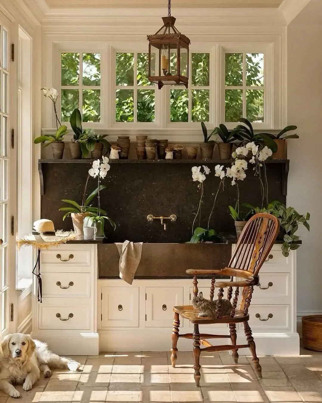 Deep stone country sink with a matching splashback slab and a brass wall-mounted tap