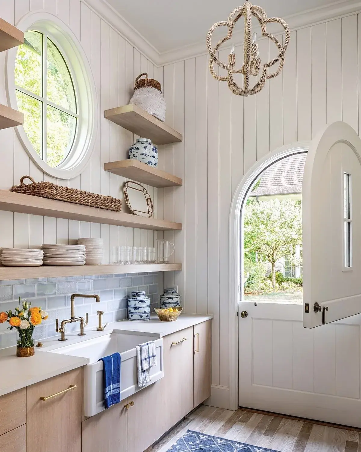 Light oak kitchen with a white apron sink, brass bridge tap and open shelves