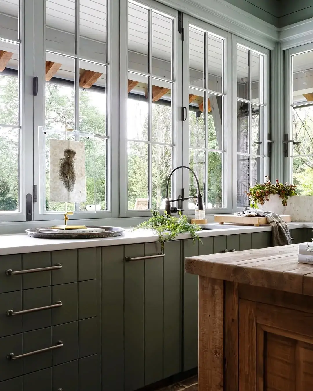 Pale olive run with timber island end, long windows and dark sink