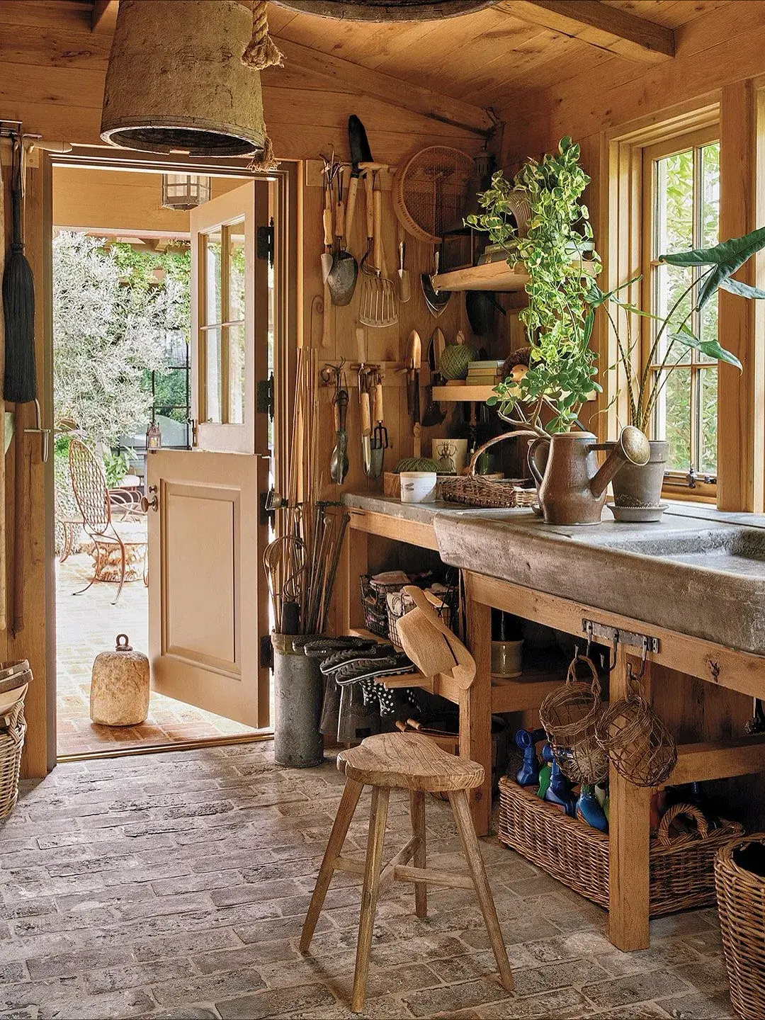 Timber potting shed with grey stone sett floor, trough sink and open garden door