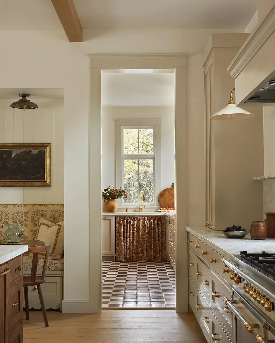 Pale timber floor meeting small brown and cream chequer in scullery beyond doorway