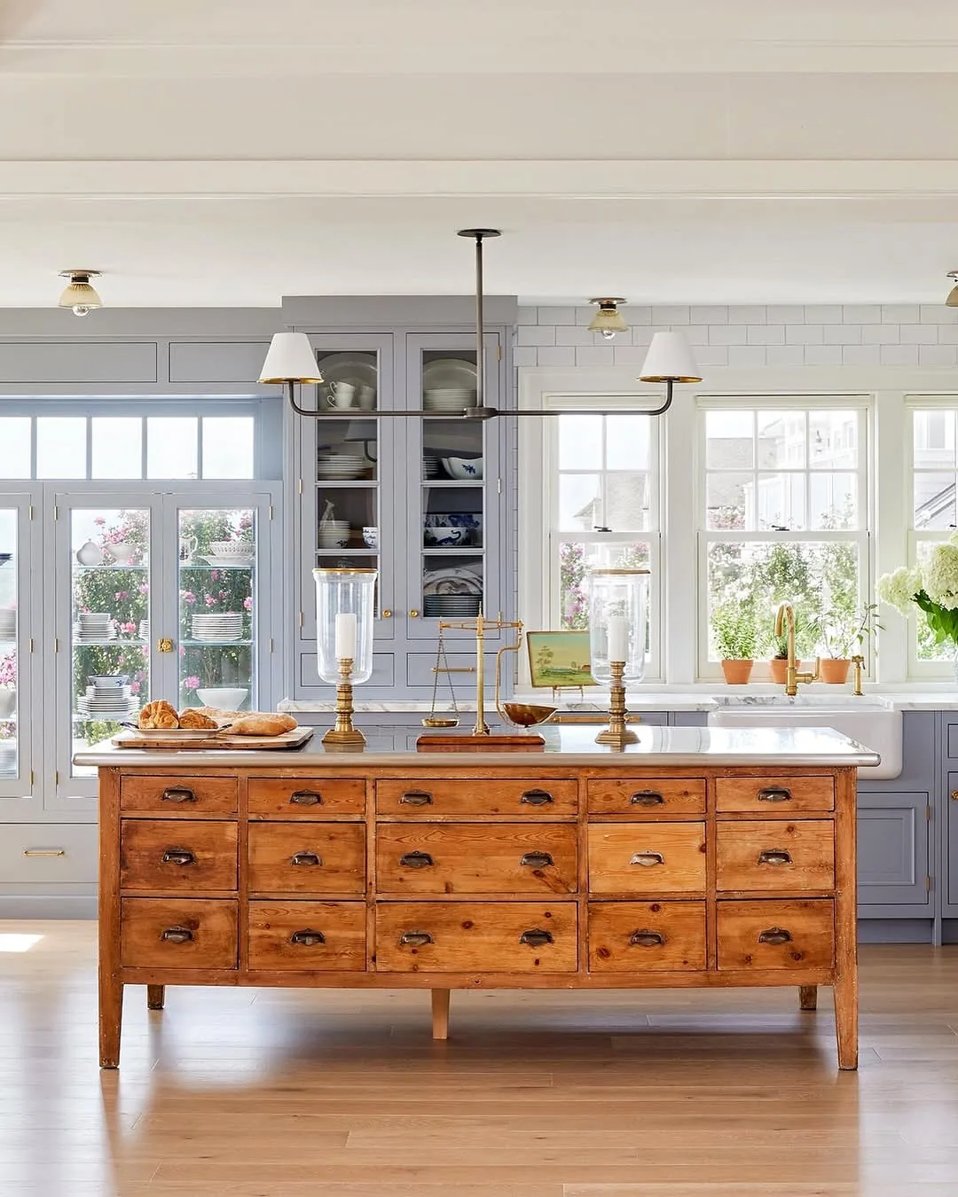 Antique pine apothecary chest used as a kitchen island with a marble top