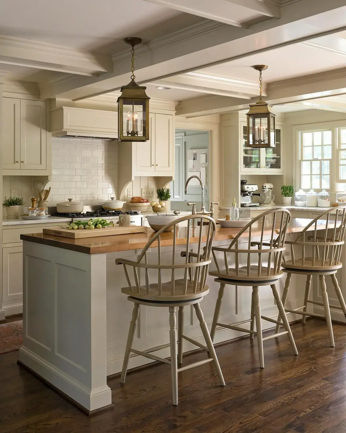 Cream farmhouse kitchen with a pale blue island base and a butcher block top