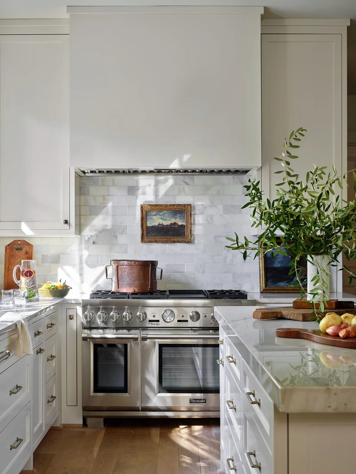 White range kitchen with marble tile splashback and a thick white marble island top