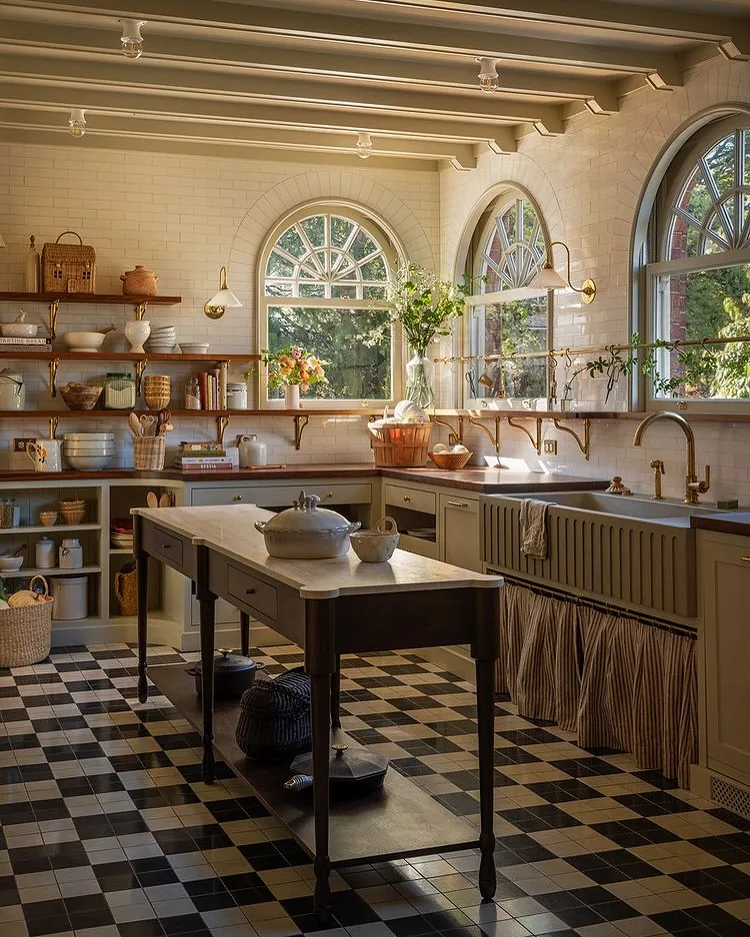 Kitchen with open oak shelves on one wall, lit by picture lights, above closed base units