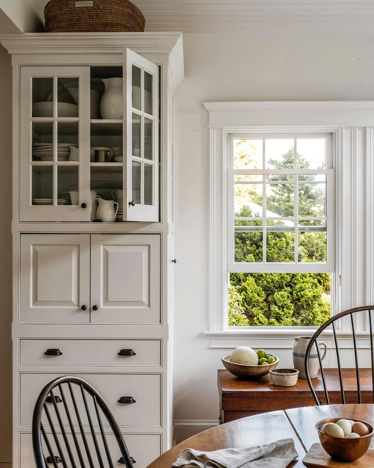 White painted built-in dresser with glazed doors above and drawers below