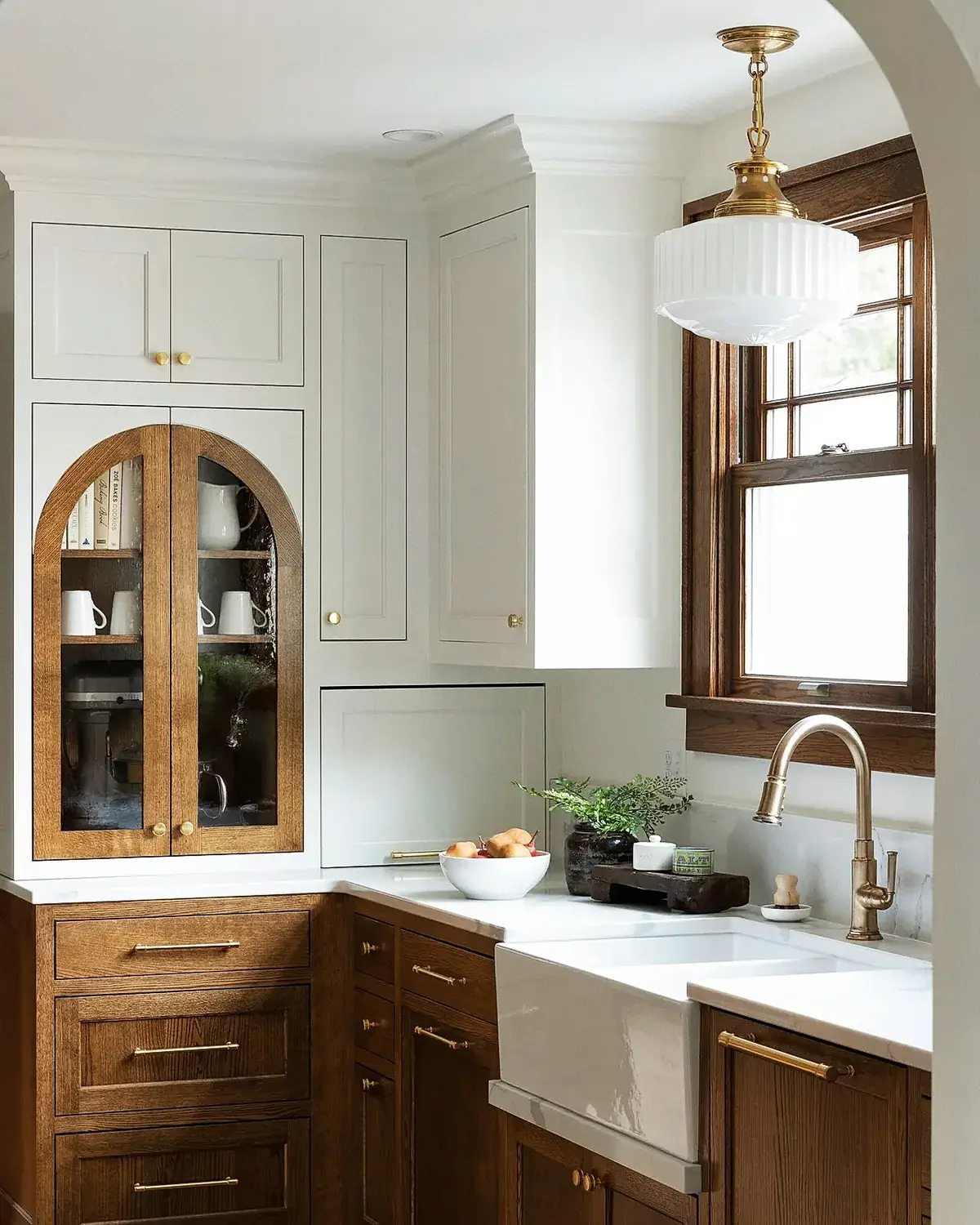 Kitchen with bone-white upper cabinets, oak lower cabinets and an arched glazed cabinet