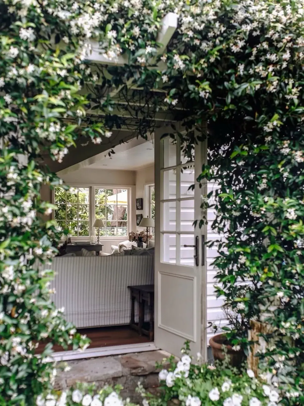 Jasmine covered doorway with a white stable door open to a sitting room