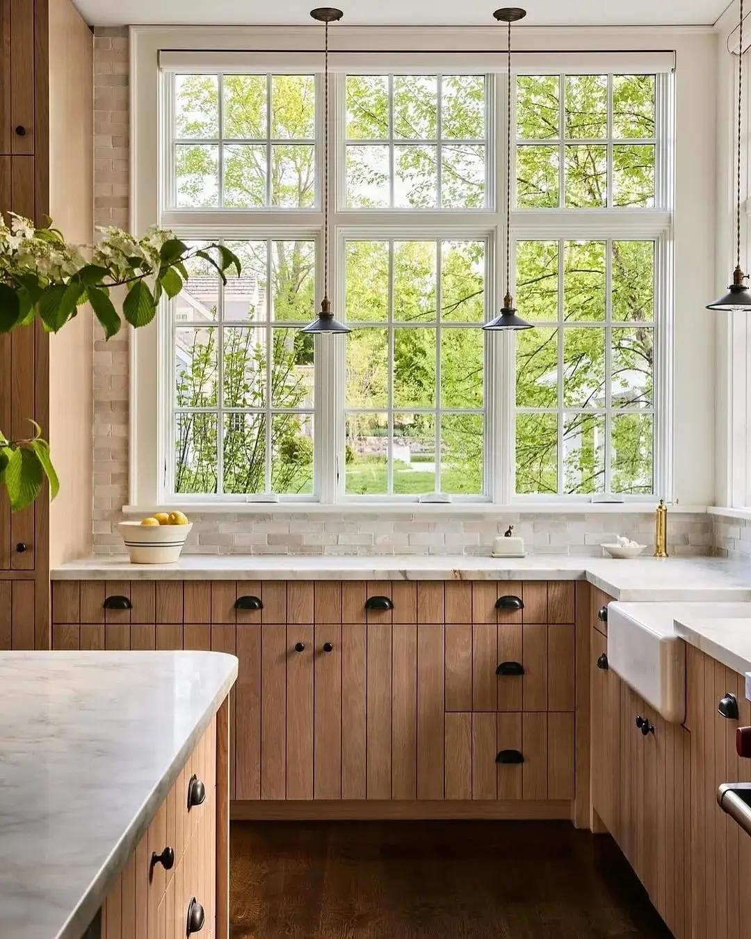 White oak kitchen cabinets with vertical grooves, straight grain and black cup pulls