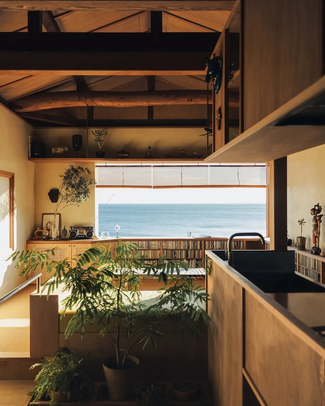 Dark timber kitchen with low cane front units facing the sea