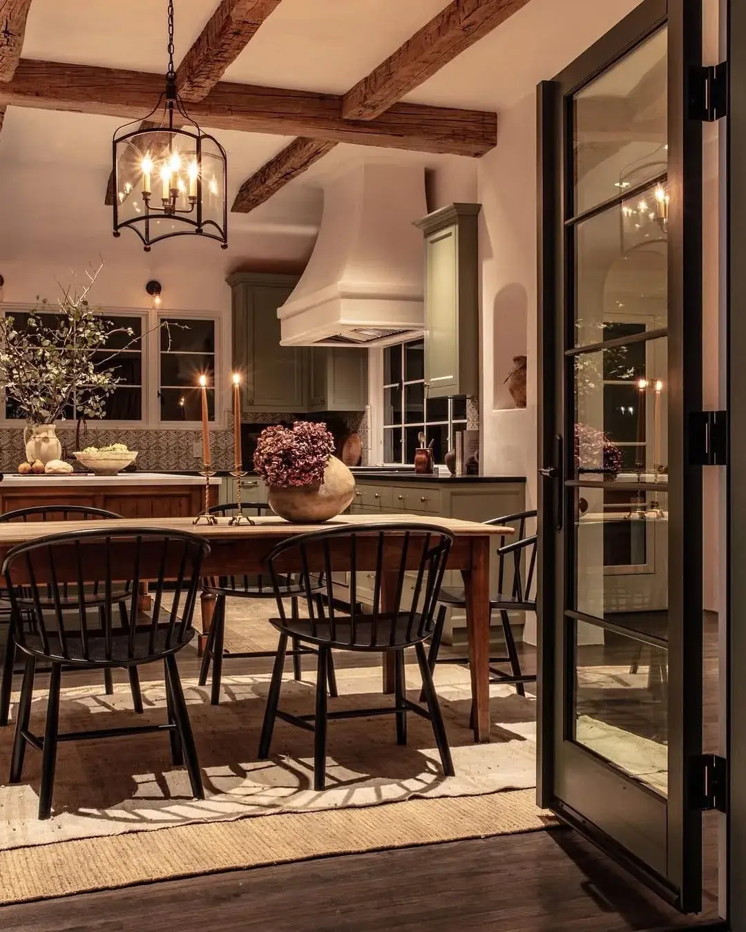 Beamed dining kitchen with oak table, black chairs and sage units