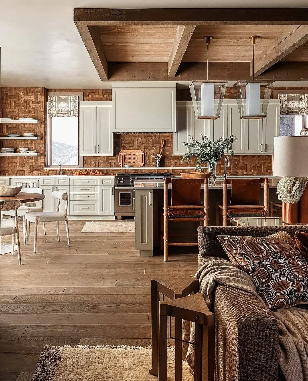 Open plan kitchen with white units, dark beam frame and mid oak floor
