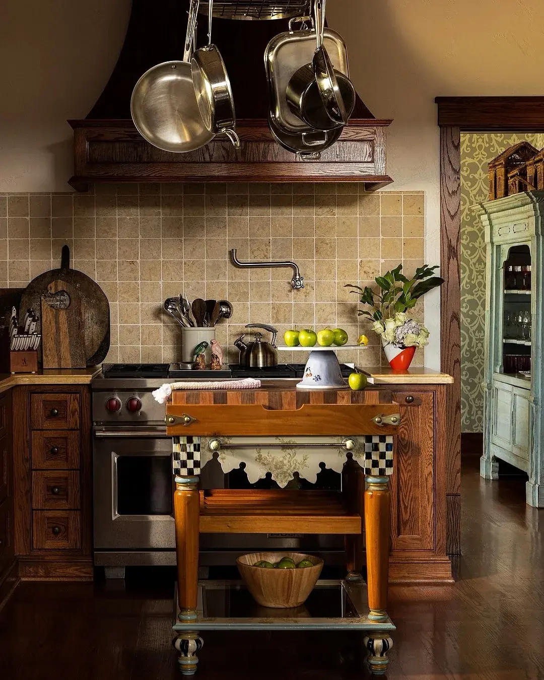 Dark oak range wall with small butcher block table and hanging pans