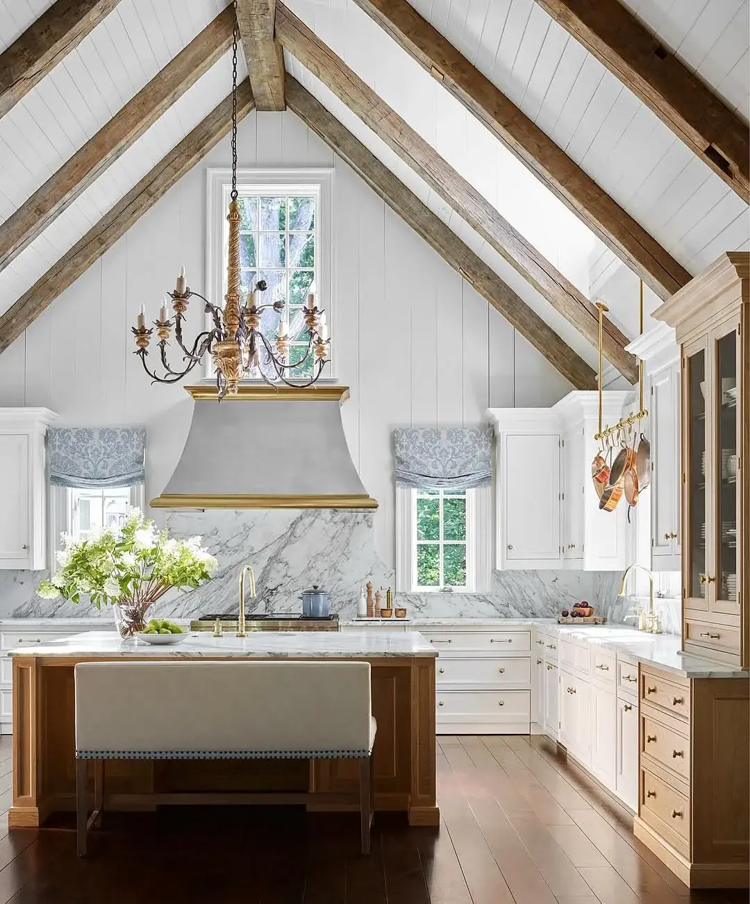 White vaulted kitchen with oak island, marble splash and reclaimed beams