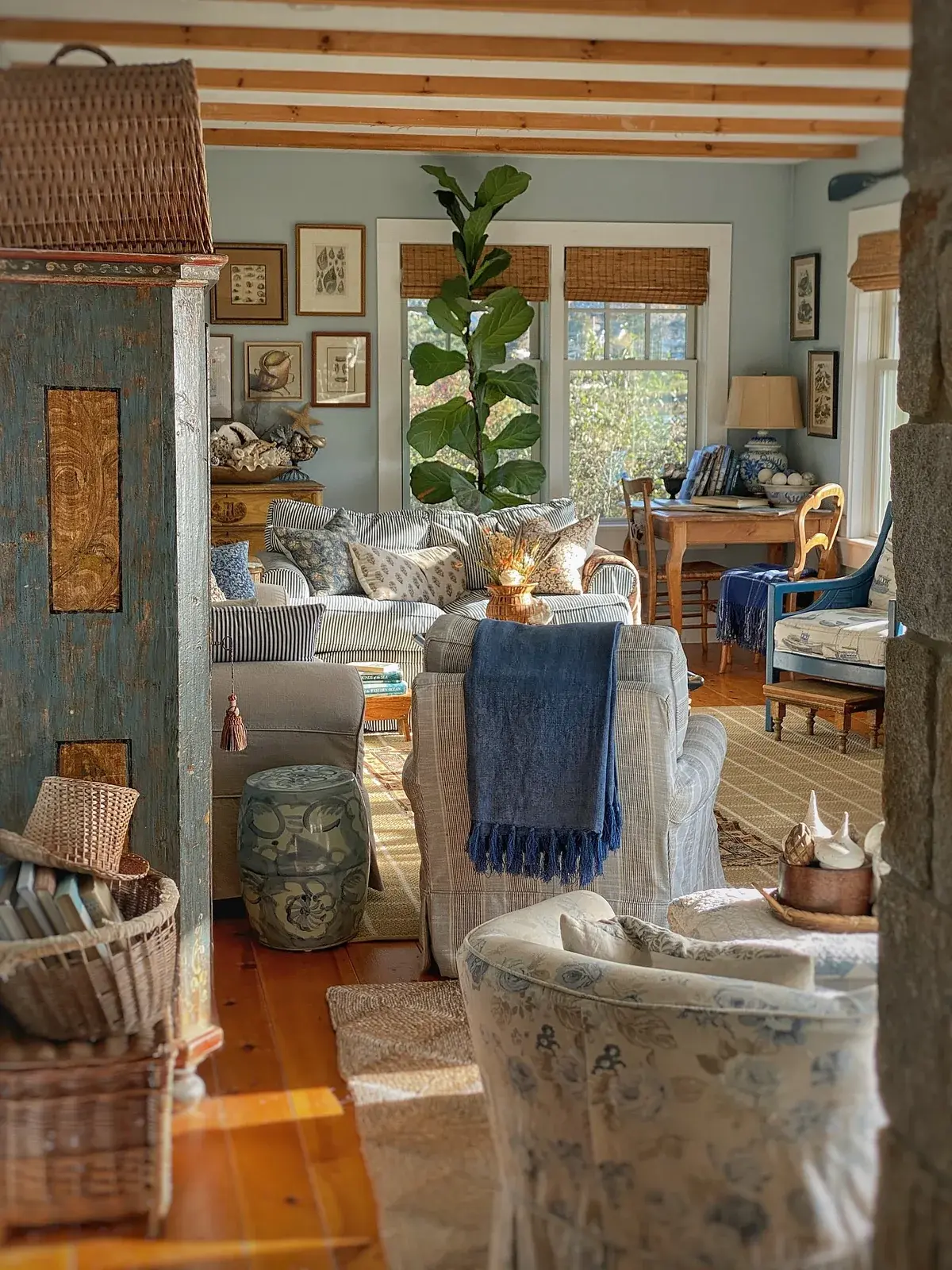 Pale blue living room with one navy throw and a warm orange pine floor