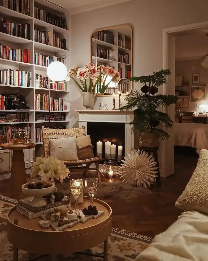 White bookcases and a lit fireplace in a cream living room at night