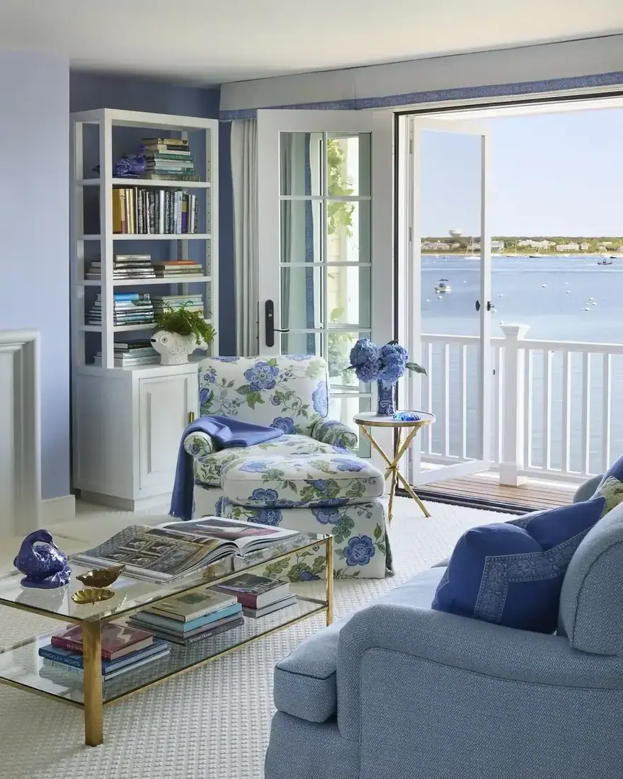 Periwinkle living room opening onto a harbour, the wall colour matching the water outside
