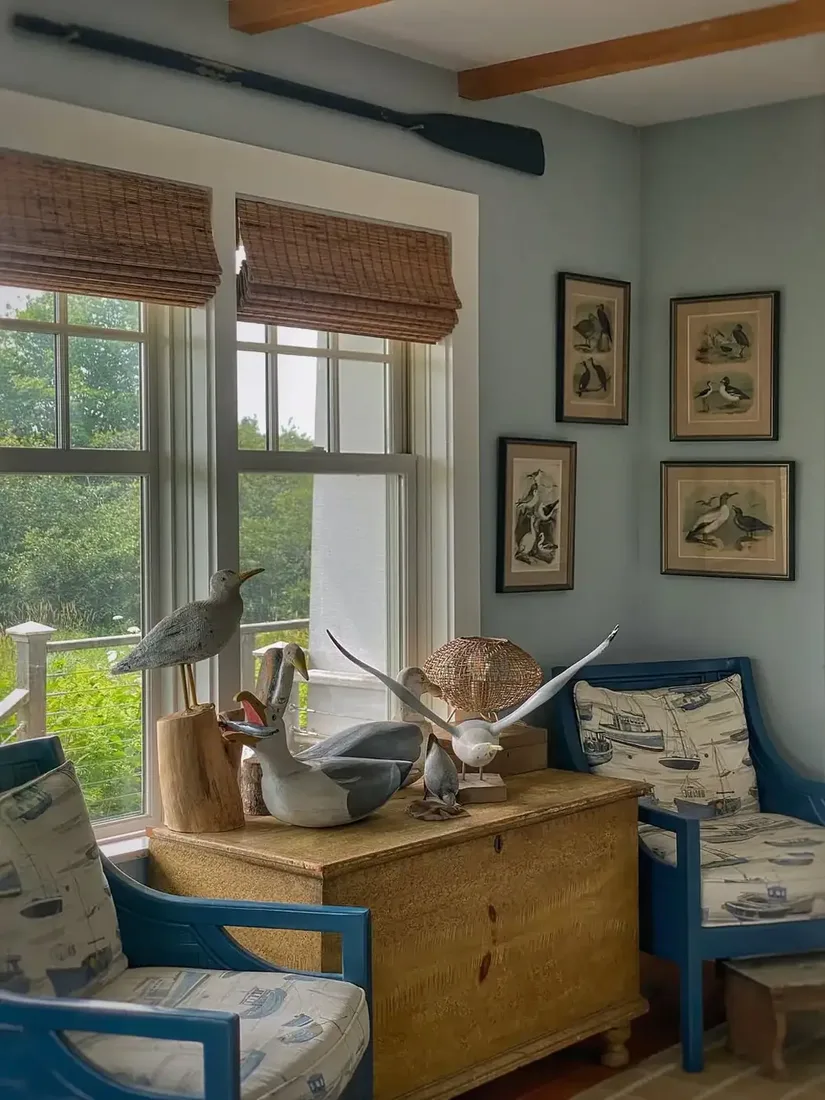 Wooden chest with carved gulls, blue chairs and oar mounted on wall