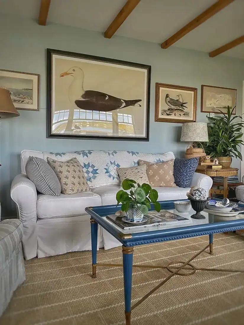 White sofa with blue tray table, large gull print and pale jute rug