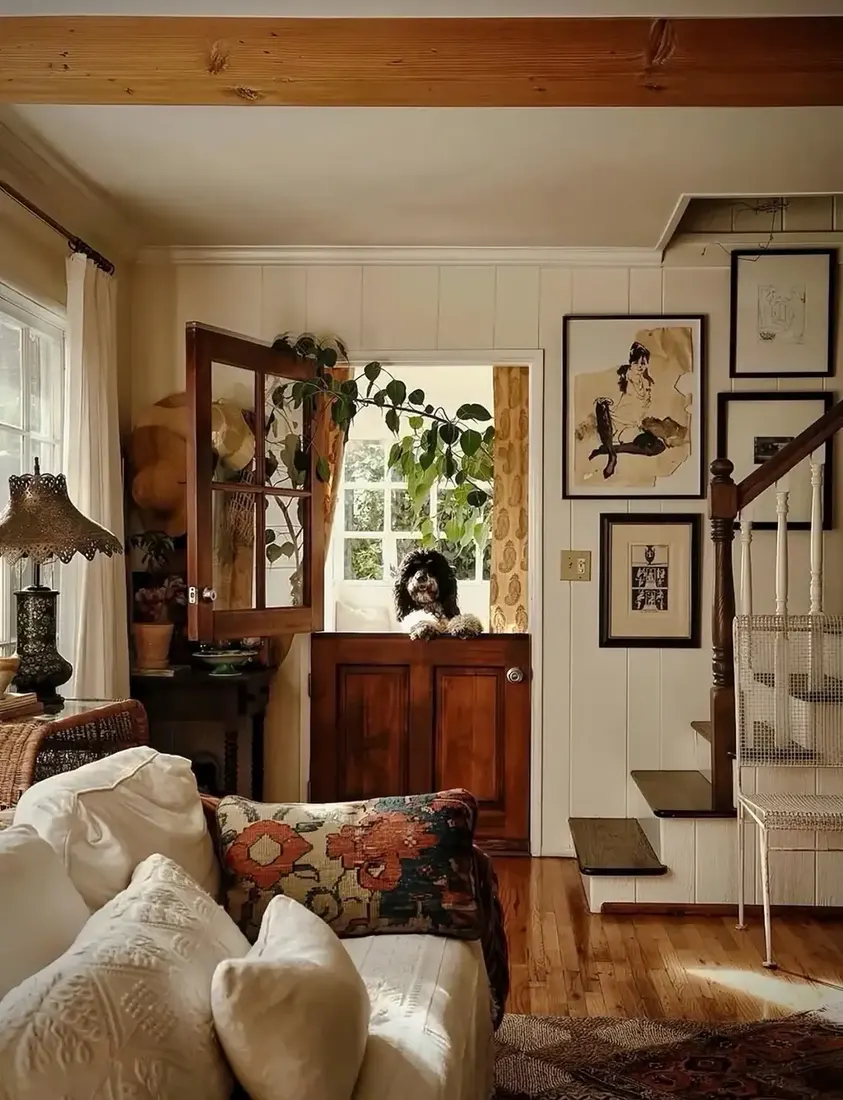 White sofa beside a stable door with a dog looking over and stairs beyond