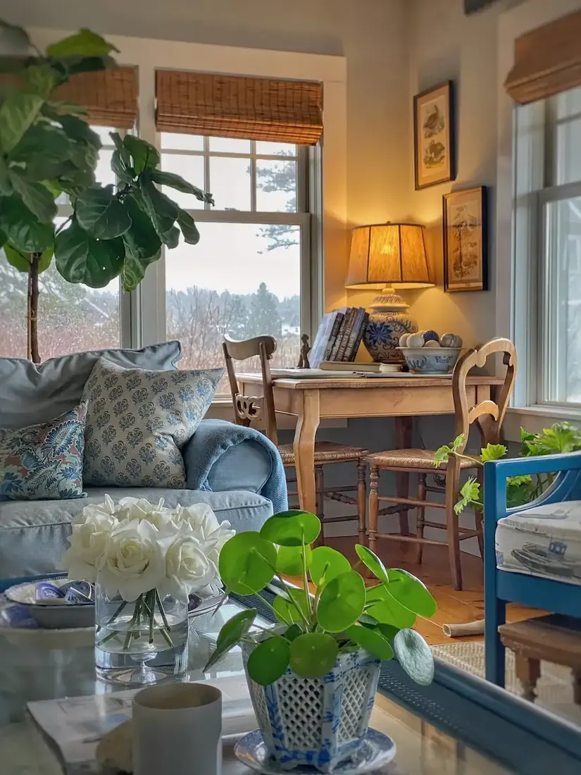 Pale blue sofa beside a pine desk with rush chairs and blue china lamp
