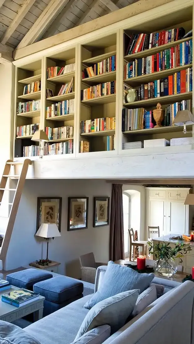 Full width white bookshelves above a sitting room with a leaning timber ladder