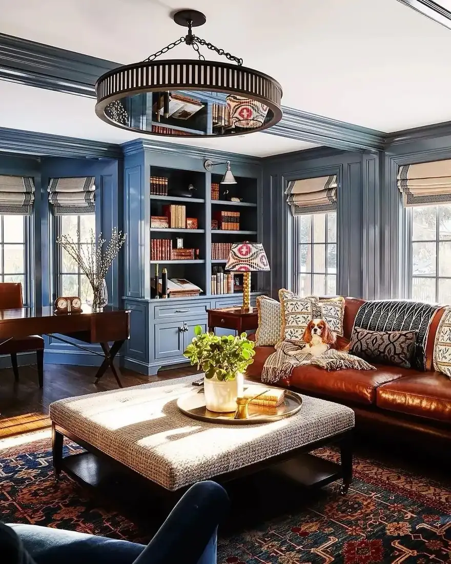 Slate blue panelled study with a fitted bookcase, drawers below, and windows either side