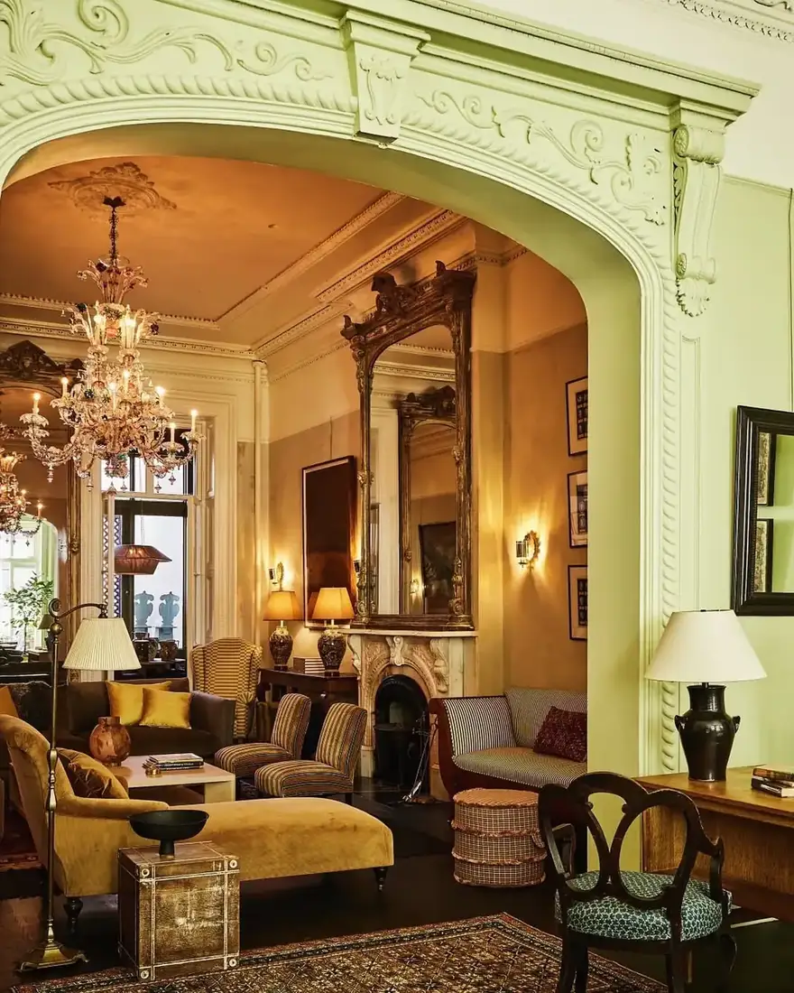 Decorative sitting room with gilt mirror above floral seating