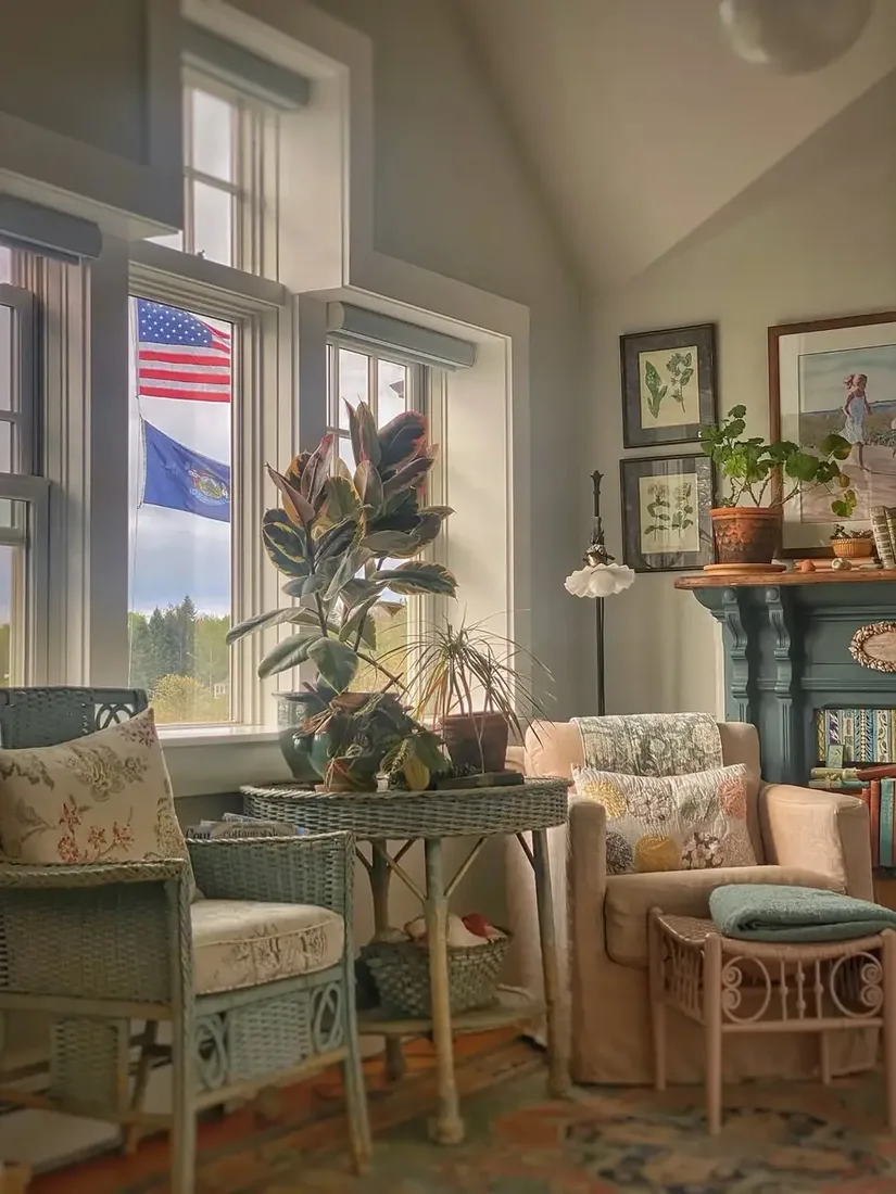 Cottage sitting room with wicker chairs beside small floral prints