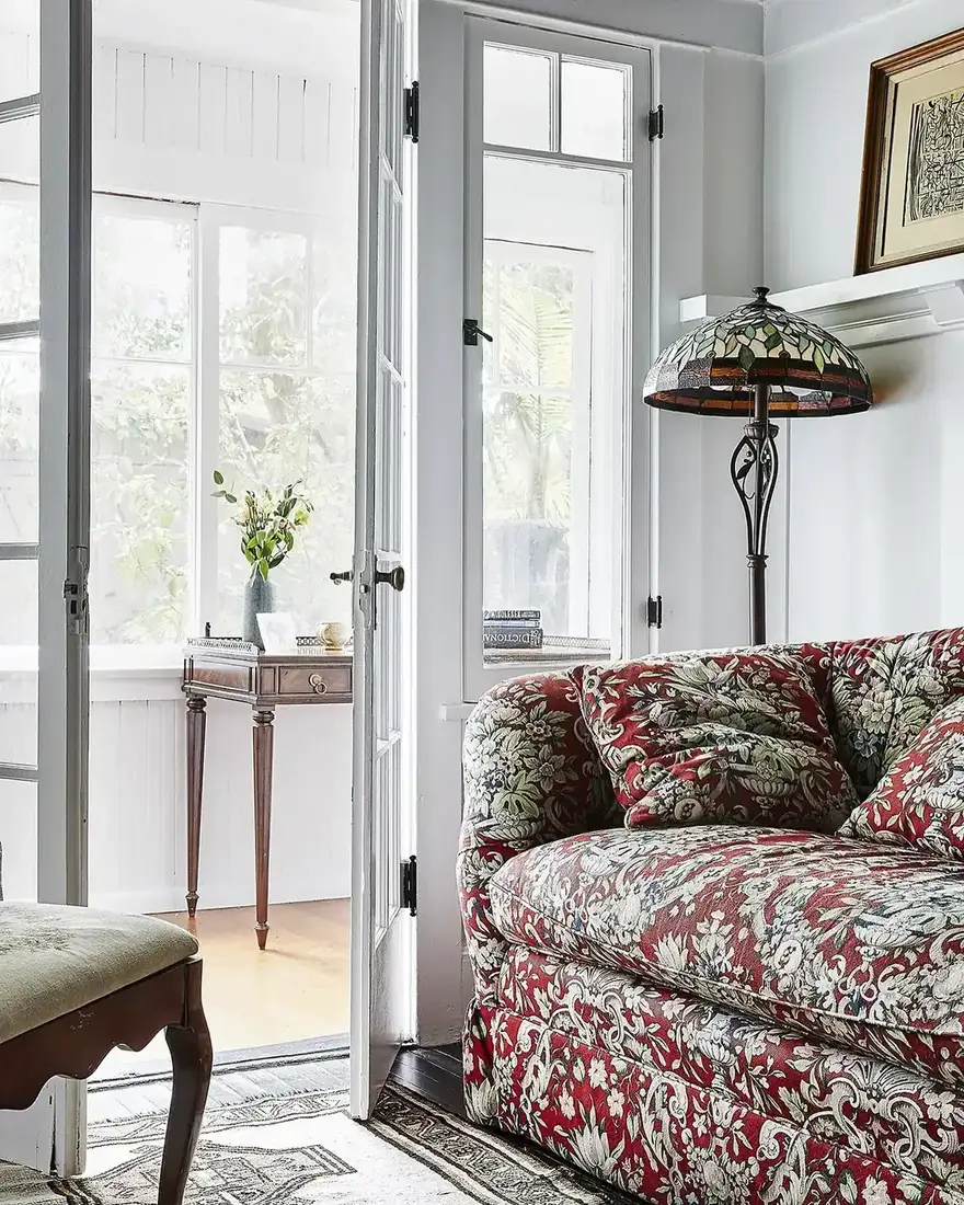 Sitting room with red floral sofa and plain companions