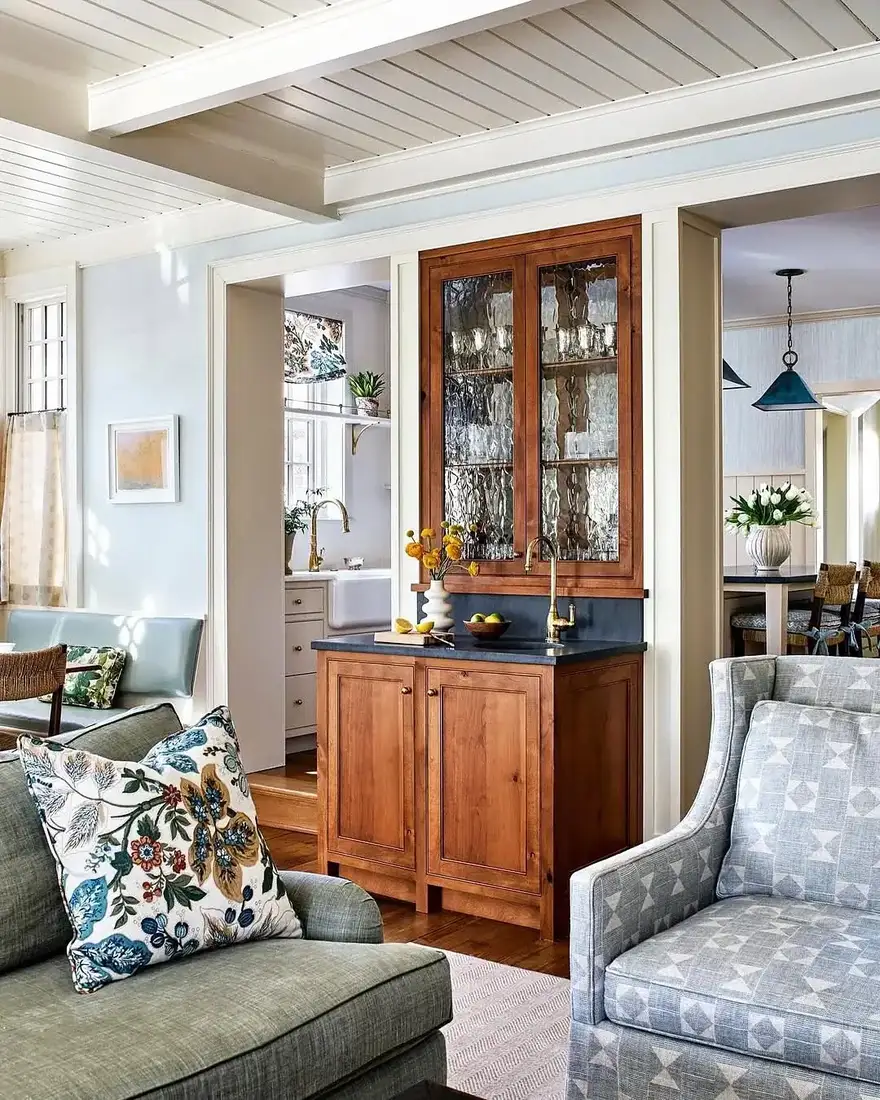 Antique pine hutch with glazed doors and a slate counter beside a pale green linen sofa