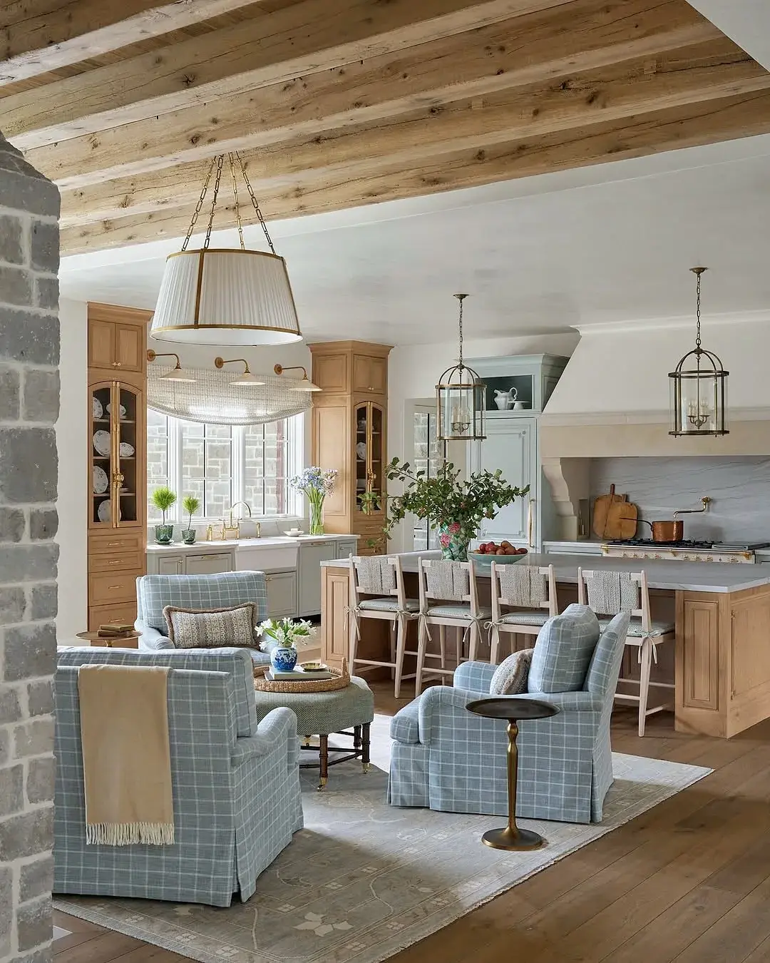 Open plan kitchen and living room with checked armchairs on a rug